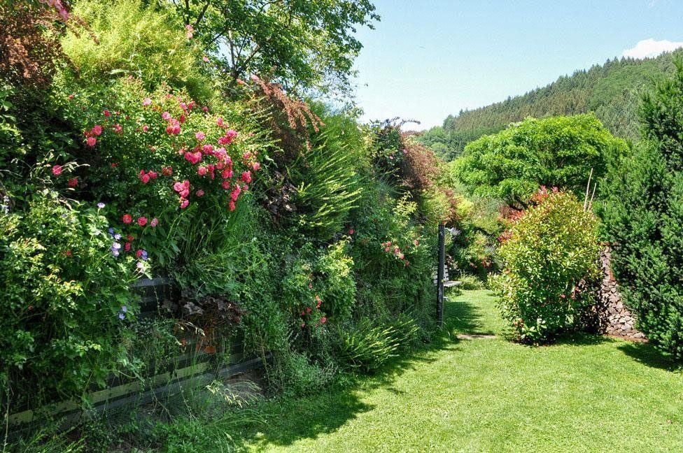 Pantalla VG-E con plantación ornamental en un jardín en ladera